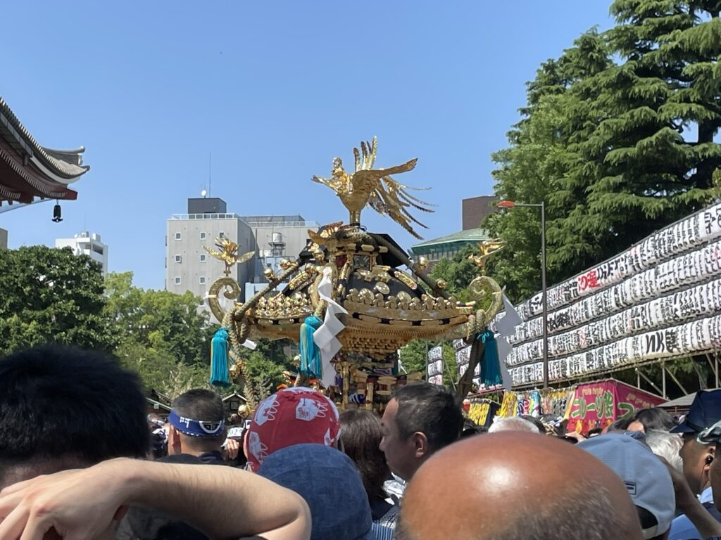 浅草神社から現れる黄金のお神輿。きらびやかな装飾が輝く。