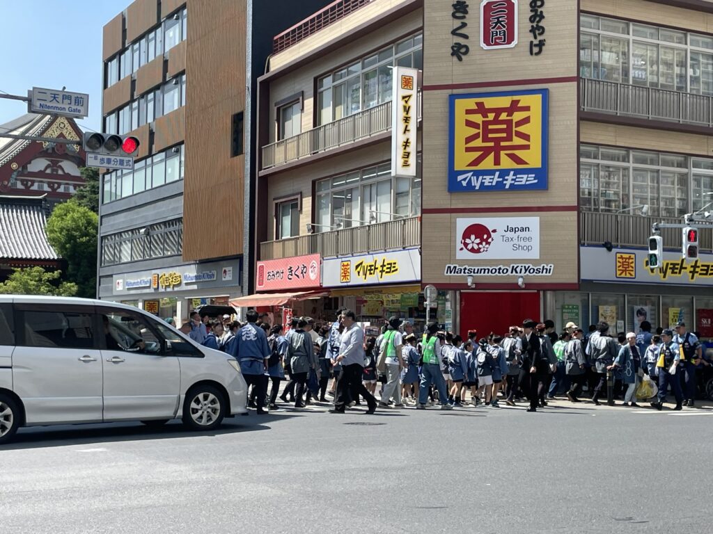 二天門から馬道通りへ出る様子。法被姿の人々が行き交う。