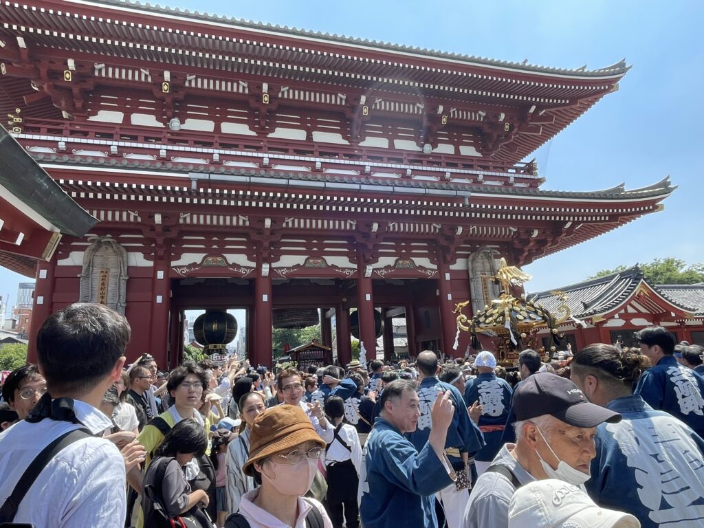 宝蔵門をバックに進む大神輿。法被姿の担ぎ手たちの掛け声が響く。