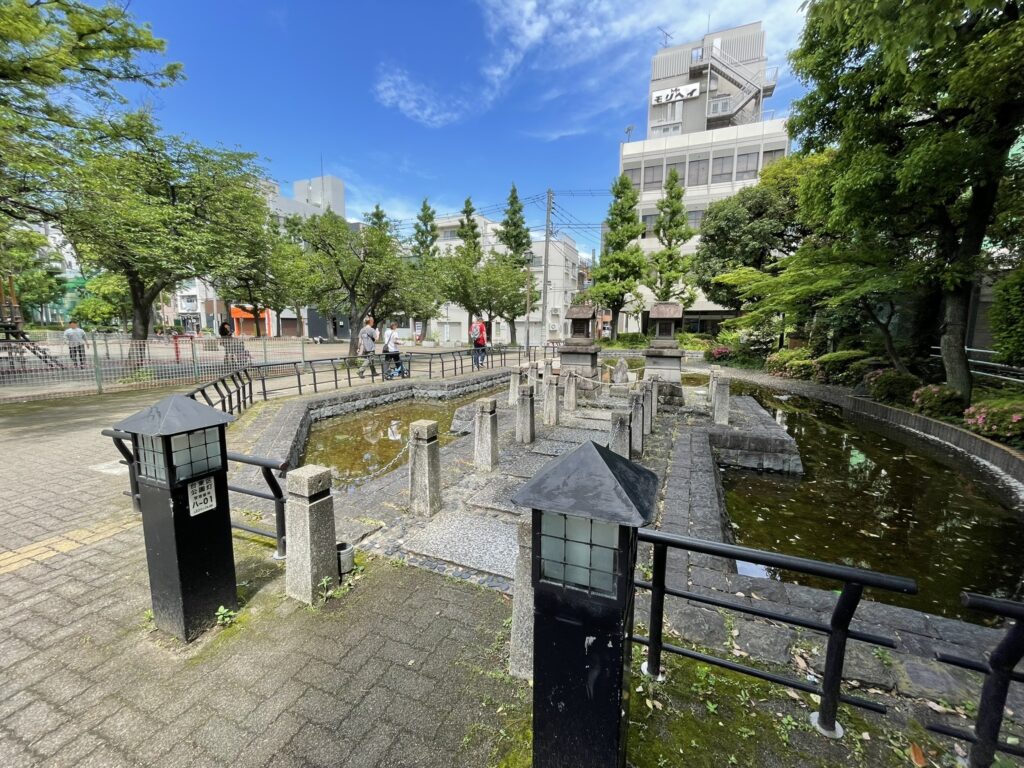 公園の一角に設けられた小さな人工池。かつての姥ヶ池を偲ぶ場所として、石碑とともに残されている。
