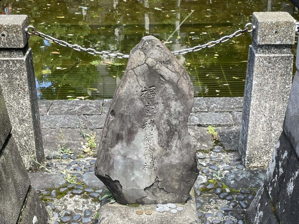 人工池に浮かぶ岩石。鎖で区切られた池の景観が、伝説の舞台の雰囲気を静かに伝えている。