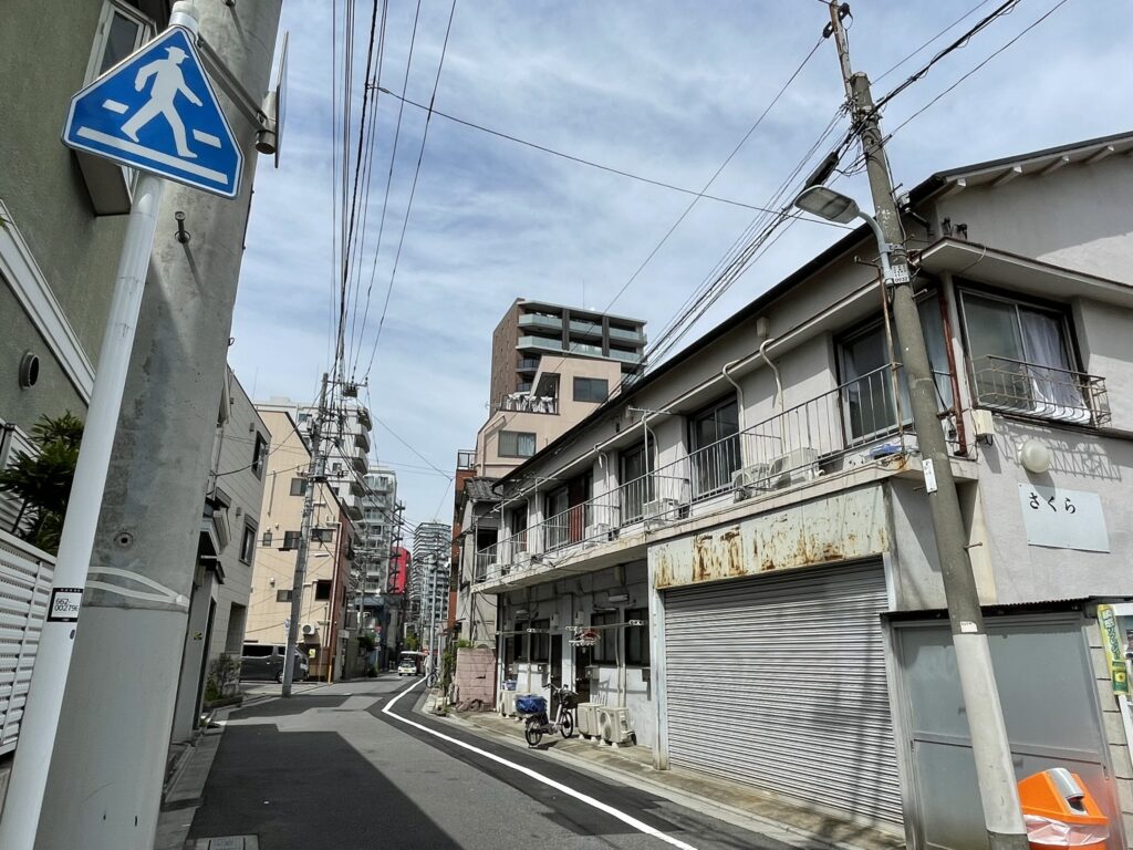 山谷エリアの交差点付近。シャッターの降りた店舗と古いビルが混在する風景。