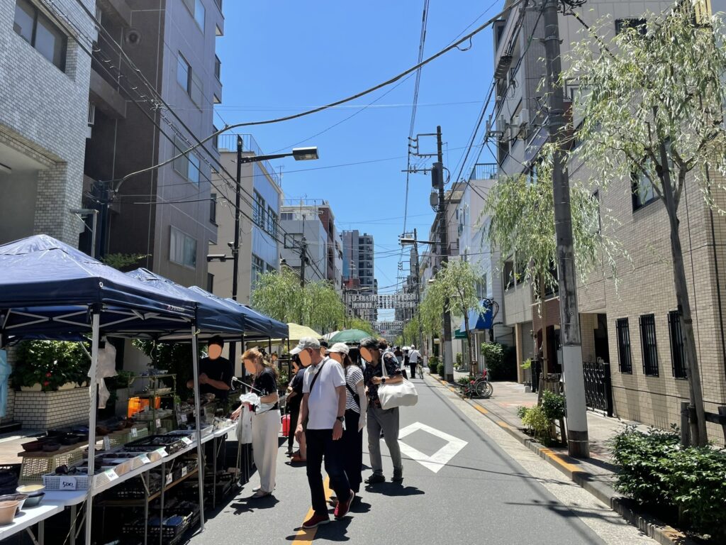 しだれ柳が涼しげな植木の露店。露店の緑が青空に映える。
