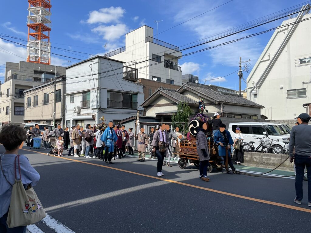 青空のもと、町内を進む神輿ど山車（だし）。
