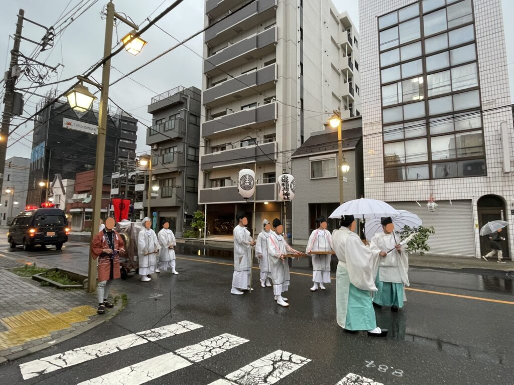 雨の中、本神輿とともに進む人々。