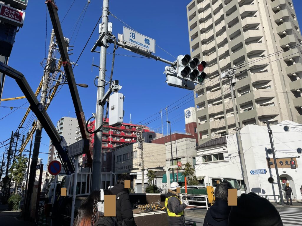 「泪橋」と書かれた交差点名標識と山谷周辺の街並み。