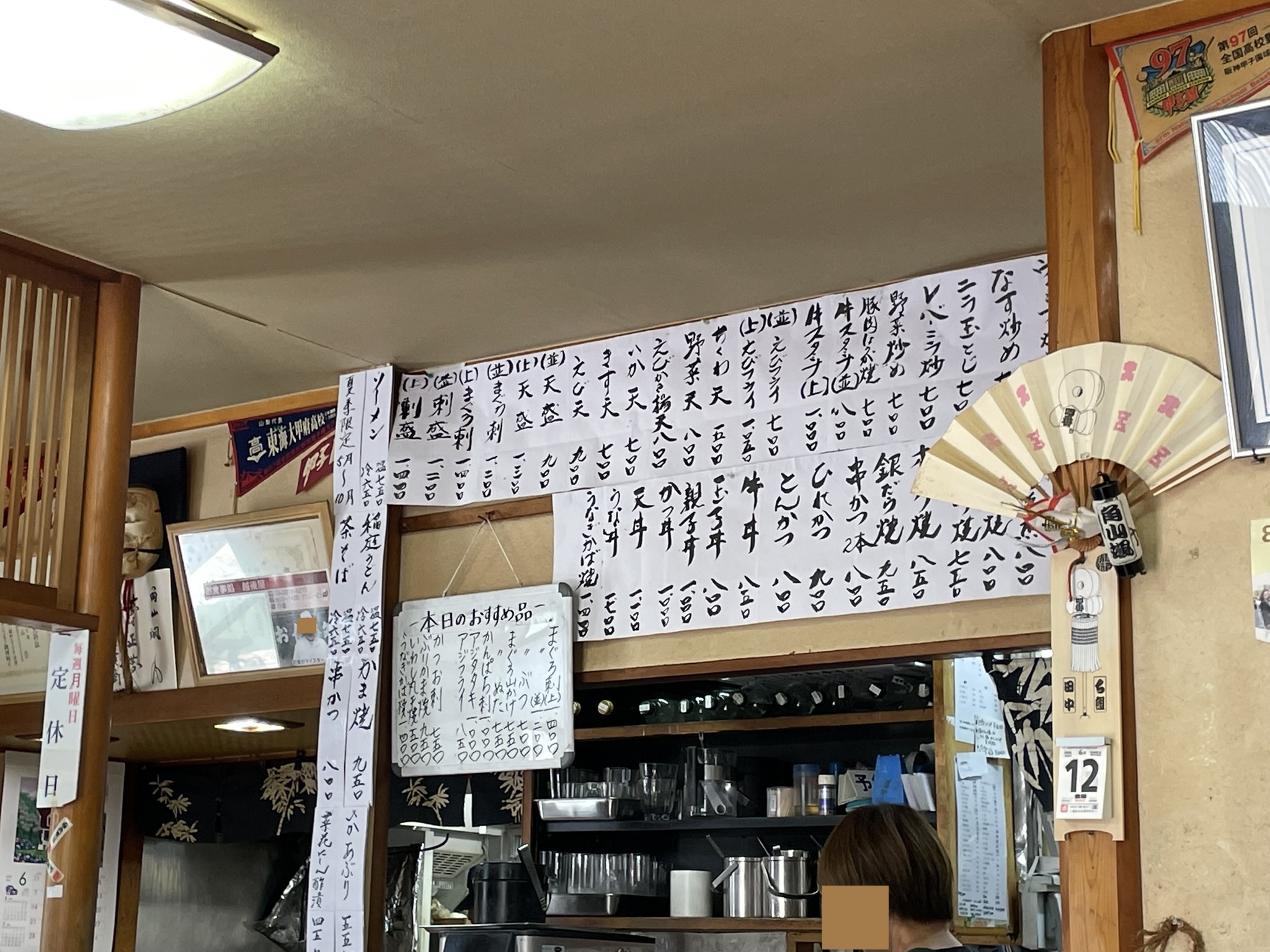 壁いっぱいに料理名が貼り出された、越後屋さんの店内