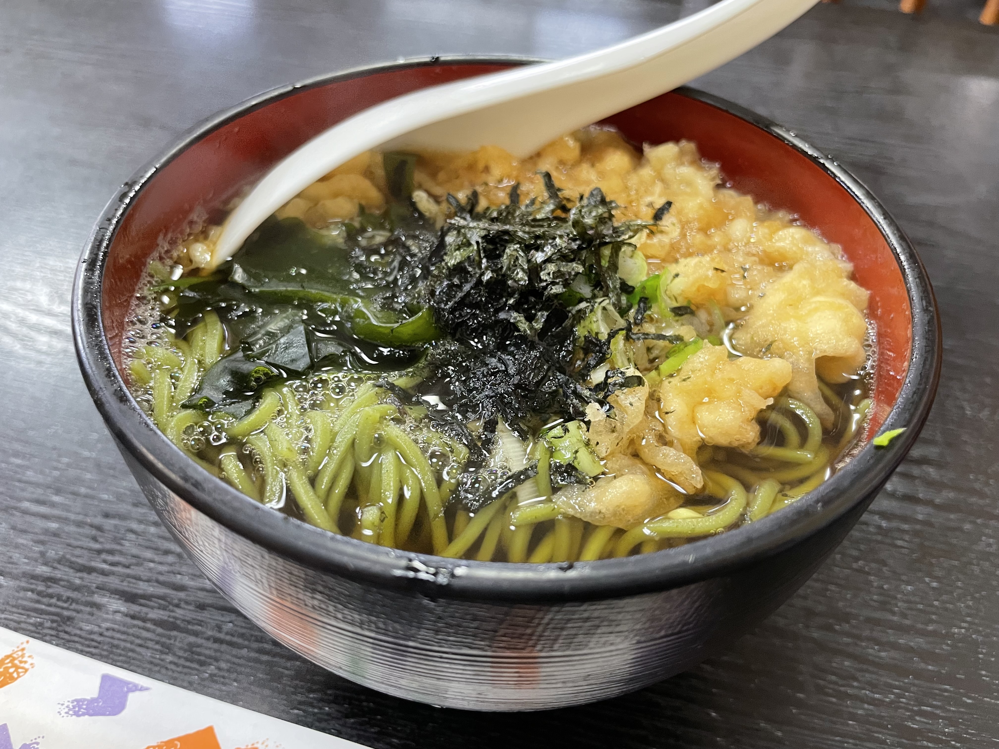 越後屋の温かい茶そば。海苔と天かす、ねぎがのっている