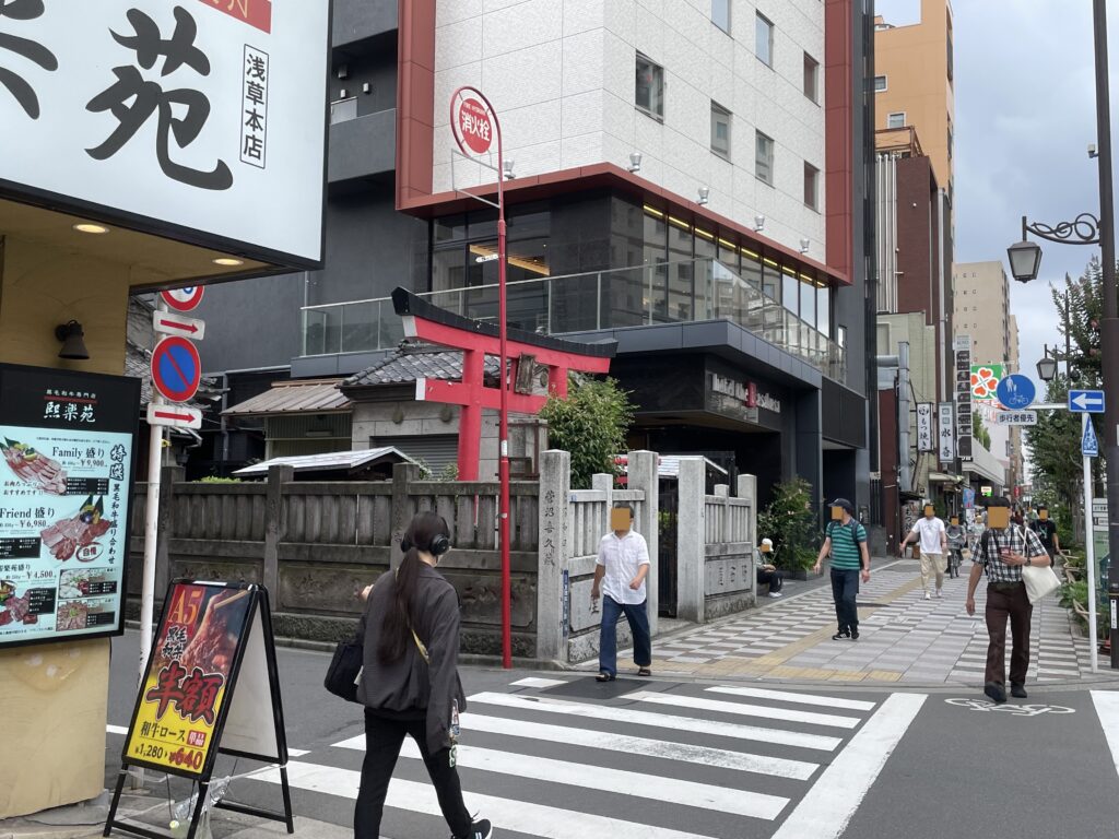 国際通りの一角。ビルにはさまれて、朱色の鳥居が佇む。