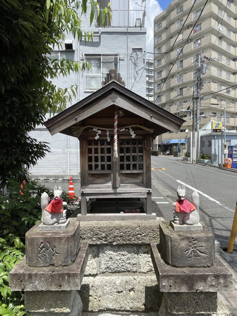 手入れの行き届いた社殿と、赤い前掛けのお狐様。
