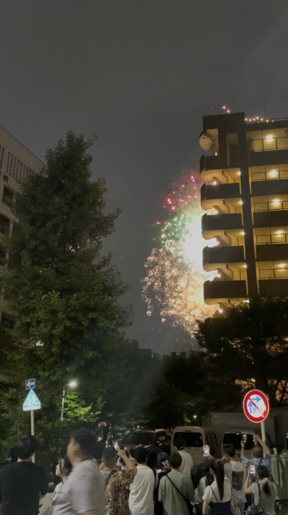 マンションの脇に上がる赤と緑の花火