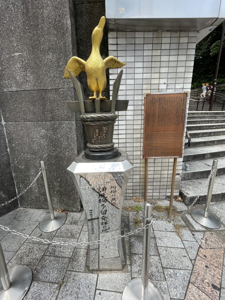 柳樽に乗った金色のあひるの像