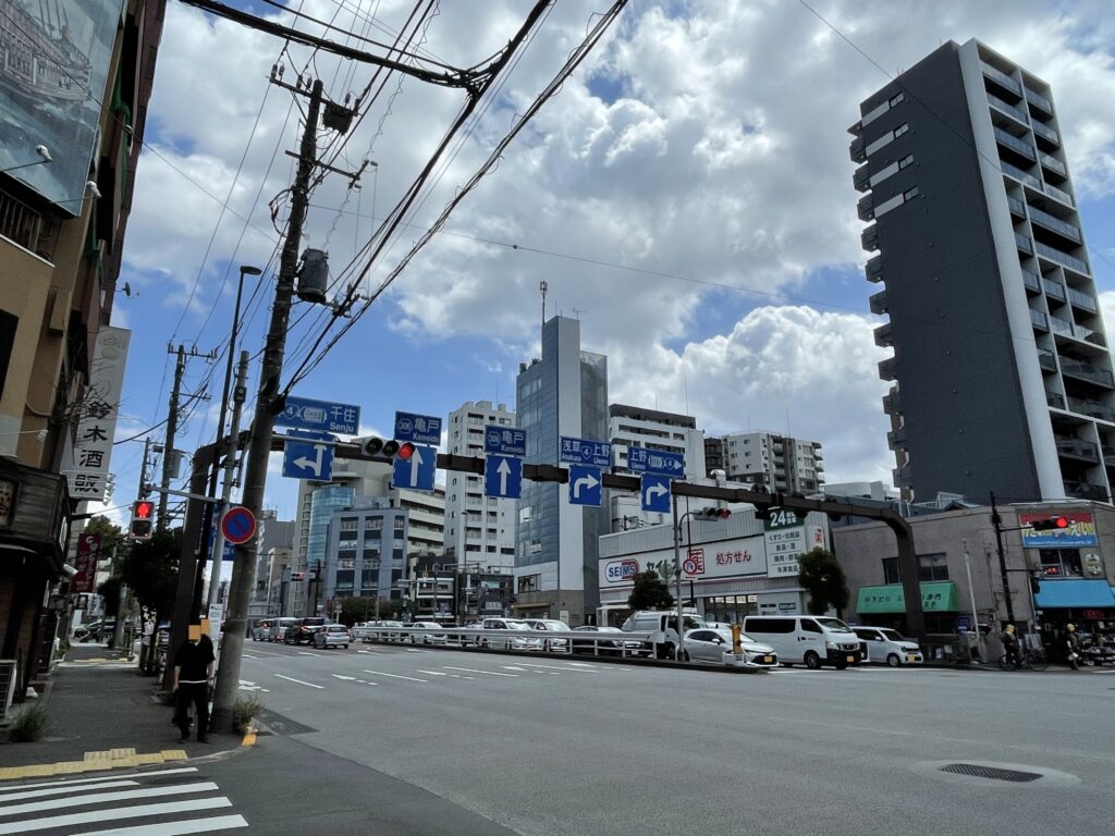 大関横丁交差点に立つ青い道路標識。千住、亀戸、浅草、上野への方向が示されている