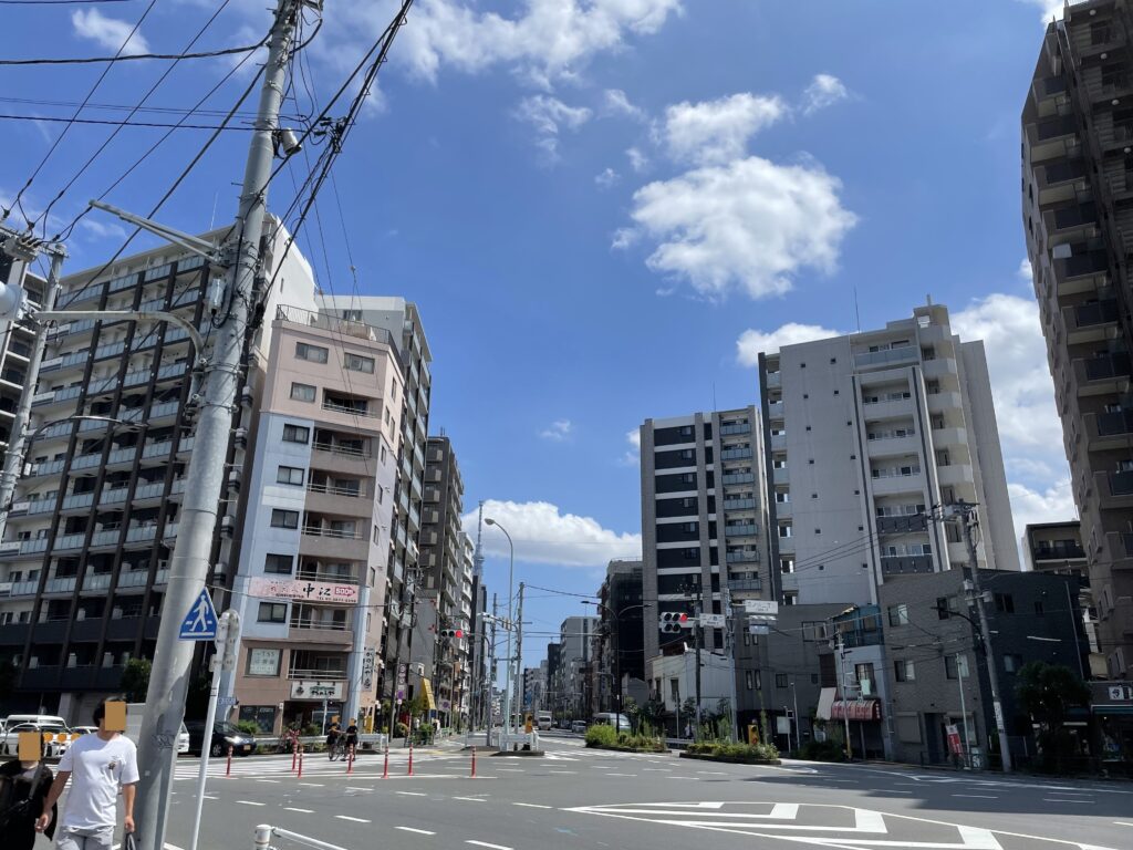 三ノ輪一丁目付近。ビルの並ぶ通りの先に、遠く東京スカイツリーが見える