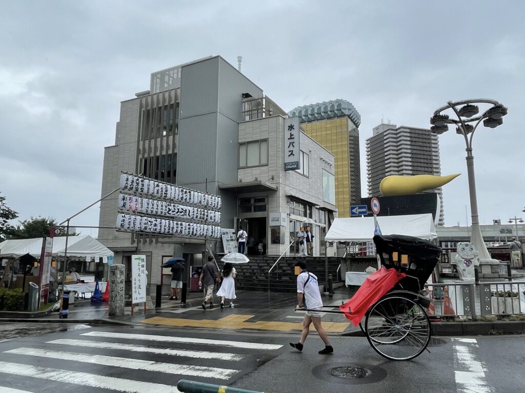 小雨の中、会場入口前を通る人力車