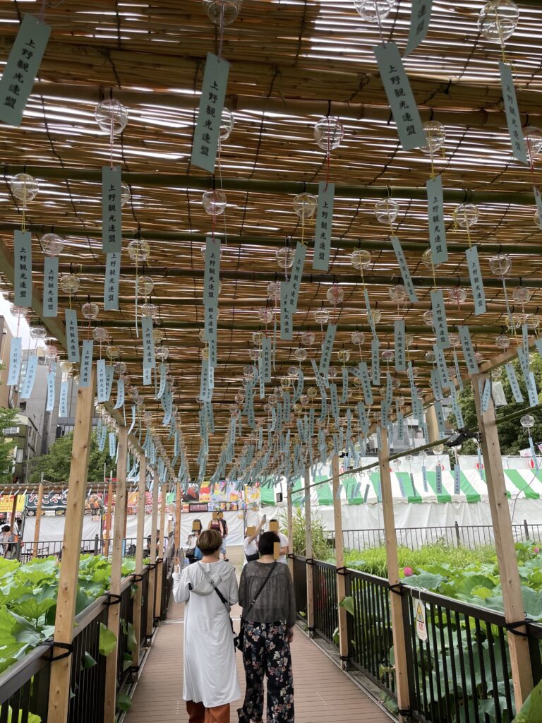 不忍池の蓮見デッキに設けられた、風鈴が下がるりんりん回廊を歩く人々
