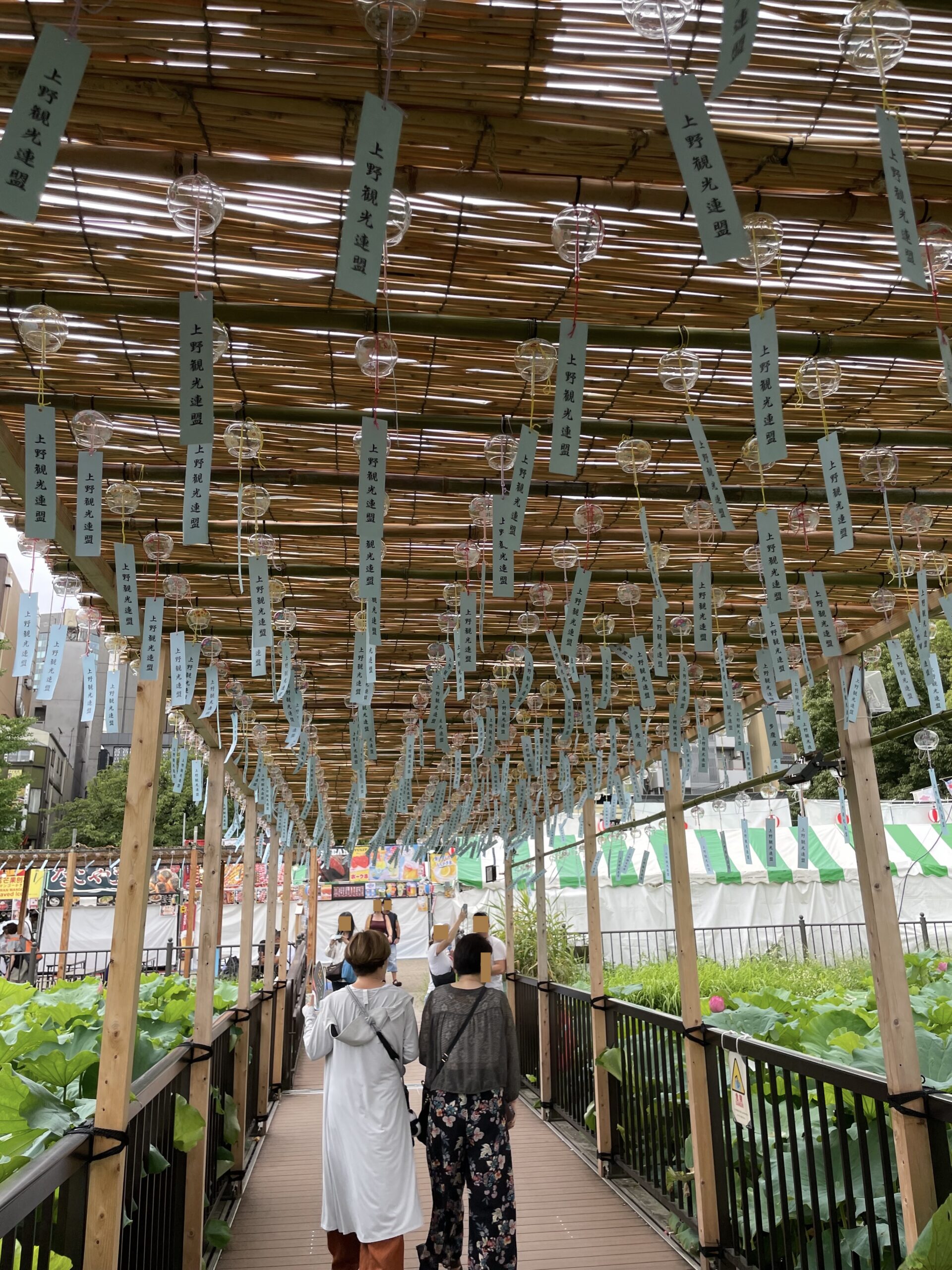 不忍池の蓮見デッキに設けられた、風鈴が下がるりんりん回廊を歩く人々