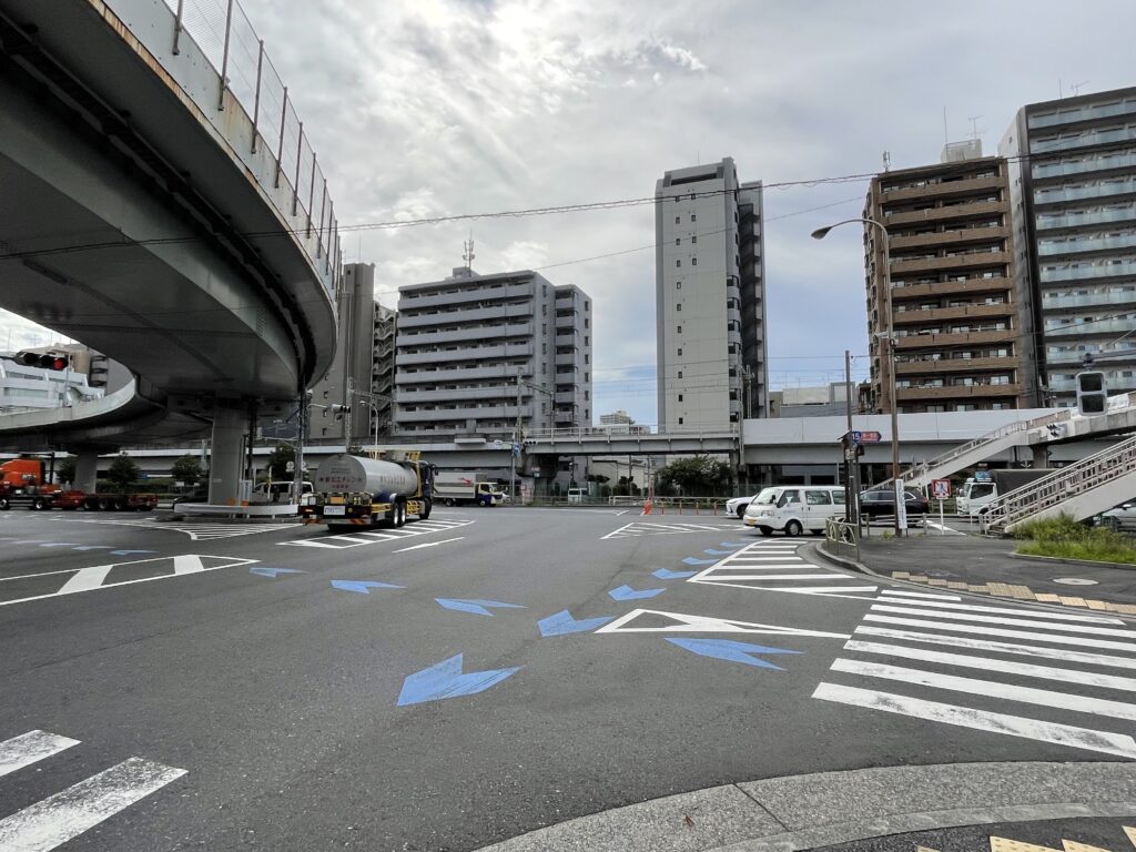 頭上を高架道路が走り、大型トラックが行き交う交差点。第一京浜の拡幅で、刑場は当時の姿をとどめていない