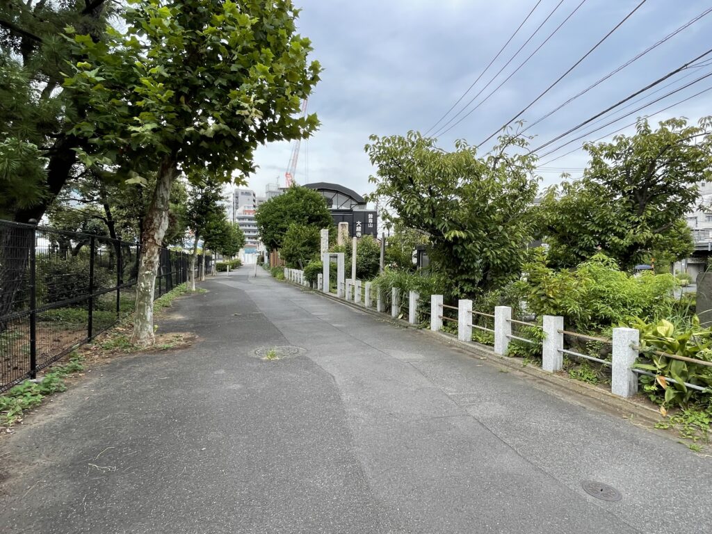 石柵に沿った道の先に「鈴森山 大経寺」の看板が見える