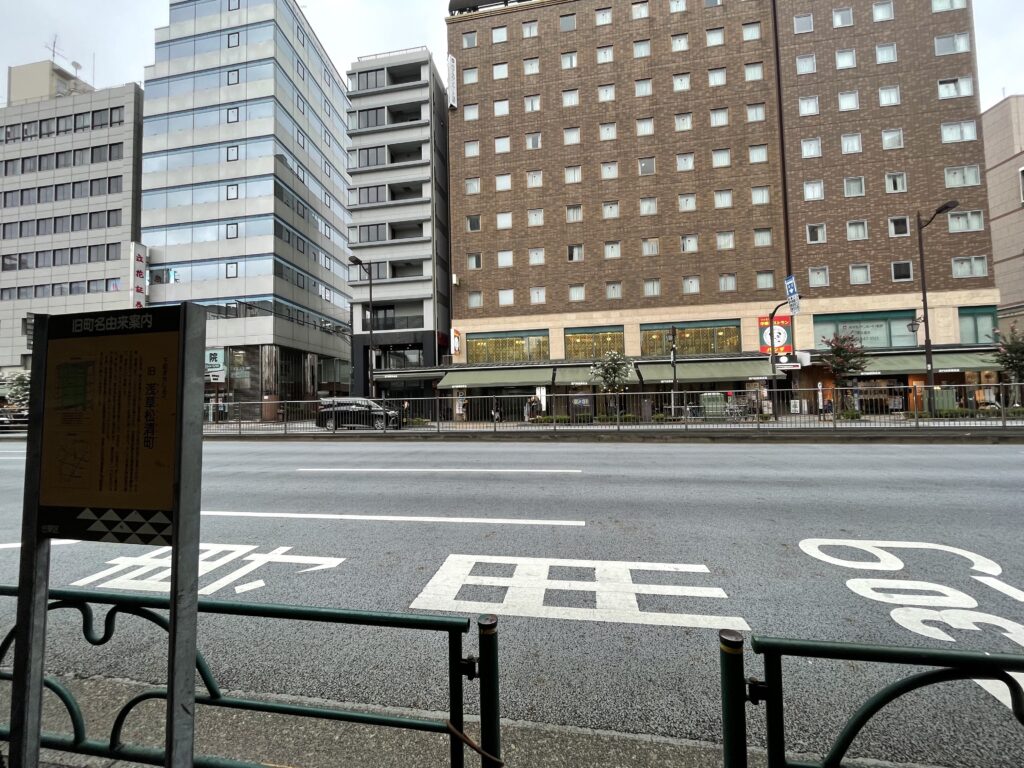 国際通りを挟んで説明板を望む。町名は消えても、説明板が歴史を伝えている