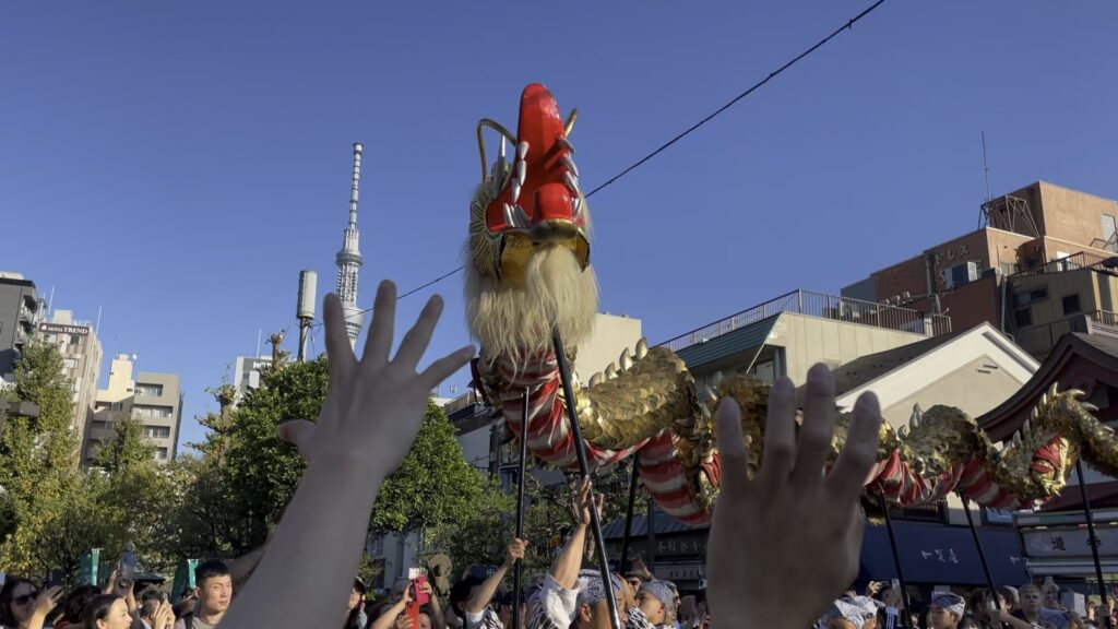 金龍が近づくと手を伸ばす観光客