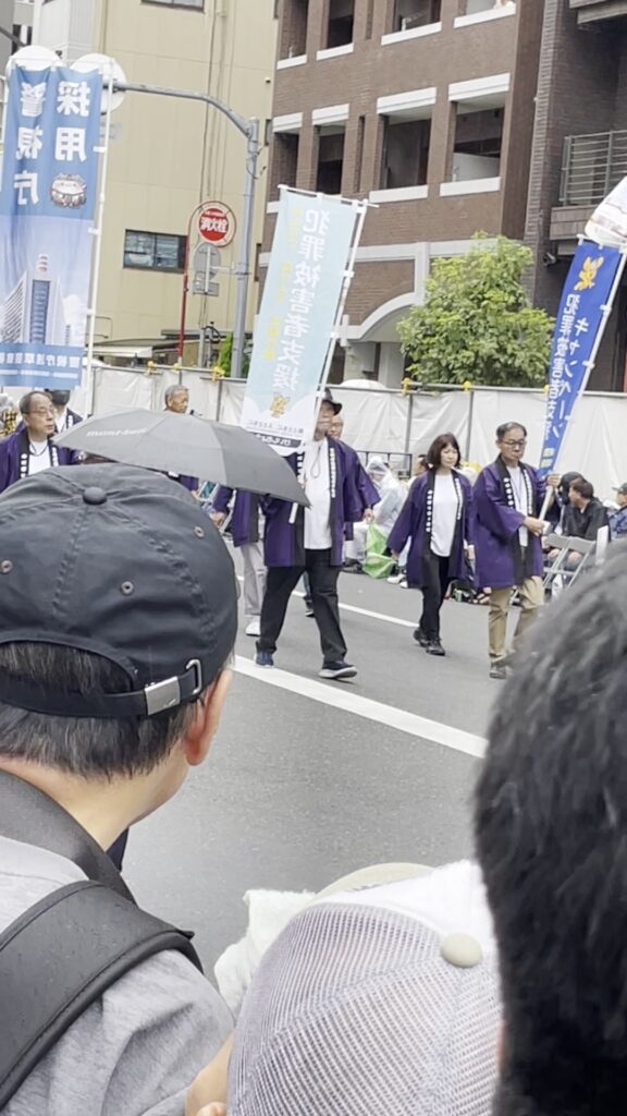 のぼり旗を掲げて歩く、浅草警察署関係のパレード。